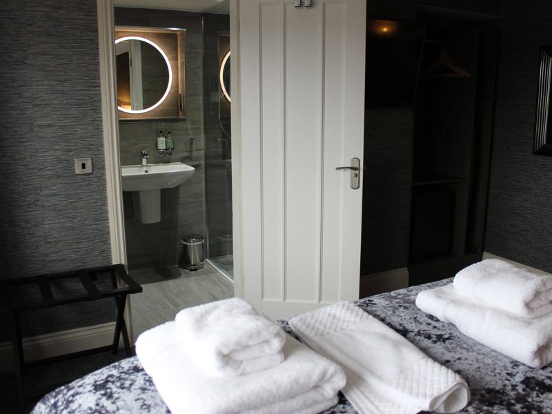 Suite 6 Double Bed with towels lookinf into Bathroom